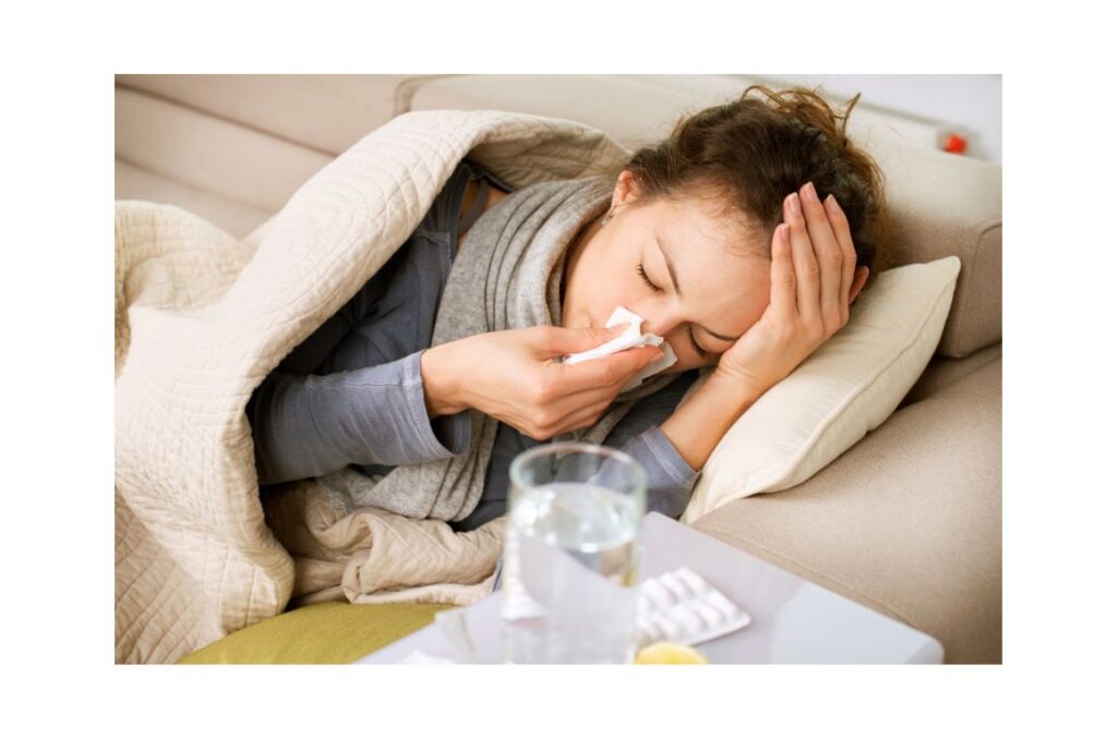 Woman with a cold laying under a blanket.