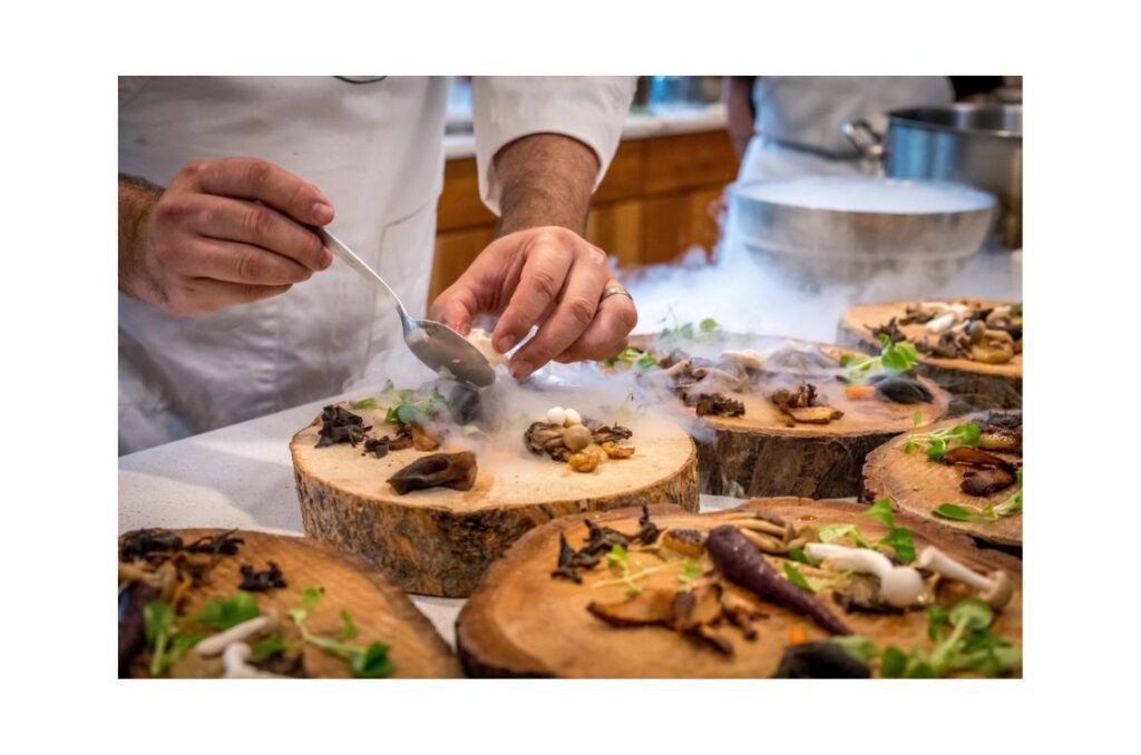 Chef preparing vegetable dish on tree slab.