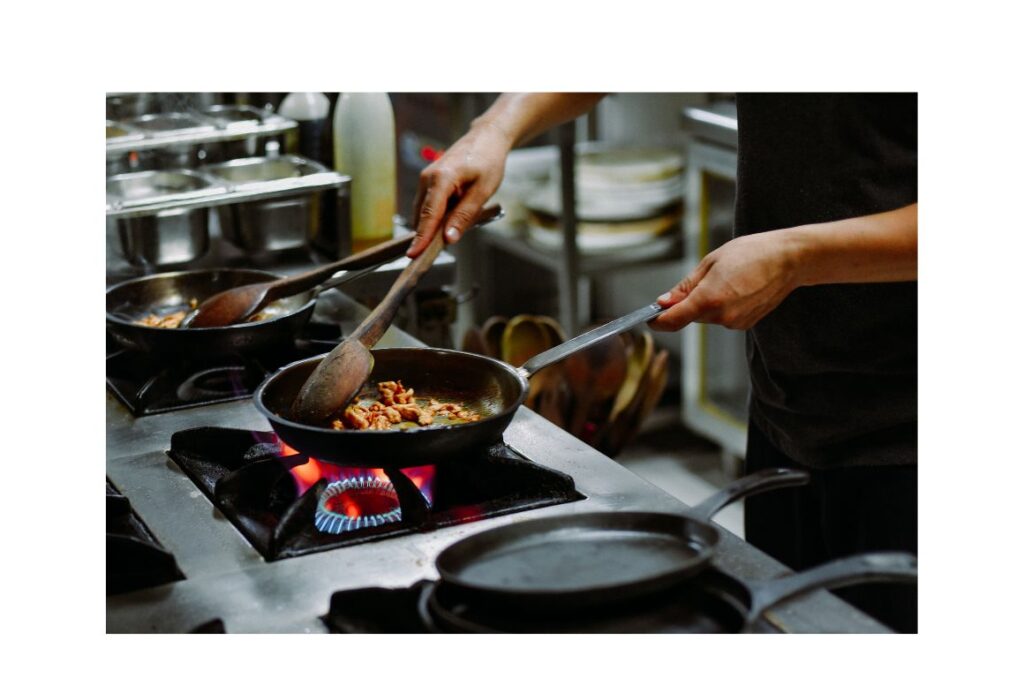 Hands cooking with an iron clad skillet.